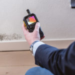 zwarte schimmel op de muur. de vochtexpert maakt een vochtmeting
