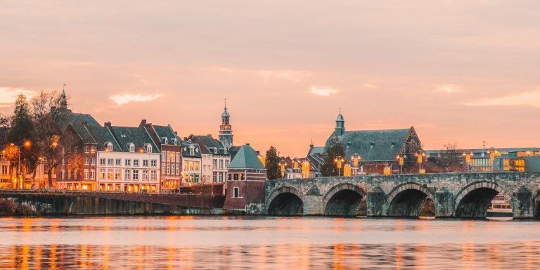 De Sint-Servaasbrug en de Maastrichtse binnenstad aan de Maas bij avondlicht