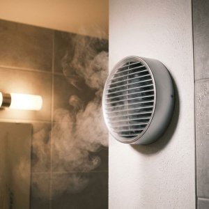 Badkamerventilator zuigt vochtige lucht weg, waterdruppels condenseren op tegels, stoom dissipeert naar ventilatie-unit