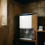 Moderne luchtontvochtiger in kelderhoek met LED-indicatoren, digitale hygrometer op plank toont vochtigheidsmetingen